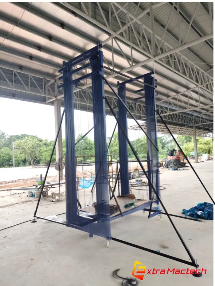 นั่งร้านไฟฟ้า10เมตร Mactech โครงเหล็กสีน้ำเงิน ตั้งใช้งานใต้โครงหลังคาเหล็กสูงในอาคารโรงงาน พร้อมขาค้ำยัน