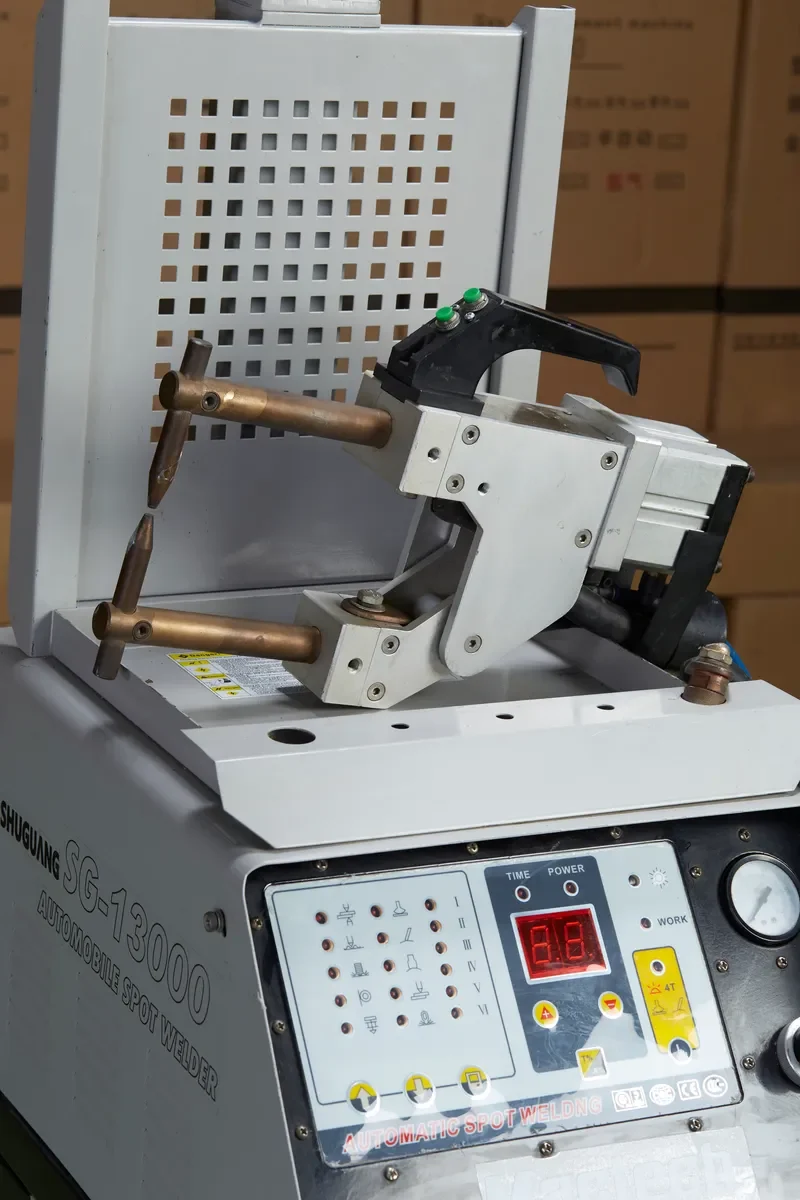 ปืนเชื่อม C-Gun ภาพใกล้ เห็นขั้วทองแดงบน-ล่างและป้ายรุ่น SG-13000 ของเครื่องเชื่อมกระตุกตัวถัง 2 หน้า Mactech